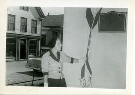 Photograph of Edith Raddall drawing a Nova Scotian flag aside to unveil the Marshall Saunders mem...