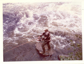 Photograph of David Archibald casting a line from the "fishing rock" below the falls on Serpentin...