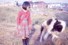 Photograph of a girl with a red dress and a dog in Nain, Newfoundland and Labrador