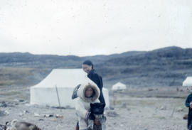 Photograph of a girl holding a dog in Cape Dorset, Northwest Territories