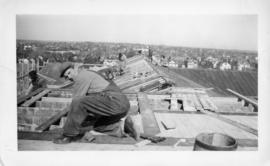 Photograph of men working on the roof of the Arts & Administration Building