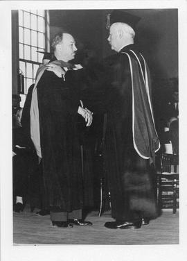 Photograph of Dr. Ross Flemington conferring an honorary degree on Henry Hicks