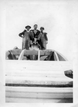 Photograph of three men standing on top of the Arts & Administration Building