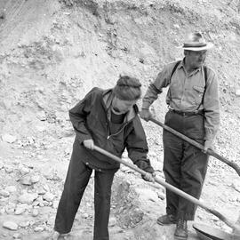 Photograph of a woman and a man with shovels