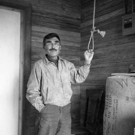 Photograph of a man with one eye ringing the bell at the St. Stephen's Anglican church in Fort Ch...