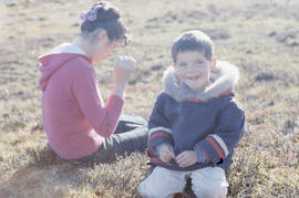 Photograph of Allie and Sam sitting outdoors in Cape Dorset, Northwest Territories