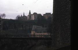 Photograph of buildings and a church from across an unidentified bridge
