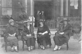 Photograph of four unidentified people sitting in chairs in front of Halifax city hall