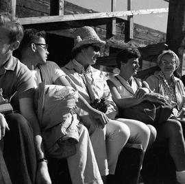 Photograph of five unidentified people sitting in a row