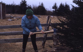 Photograph of Barbara Hinds chopping wood