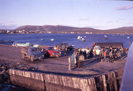 Photograph of several people and trucks on a pier in Cartwright, Newfoundland and Labrador