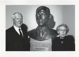 Photograph of Norman A. M. MacKenzie with a bust of himself and an unidentified woman