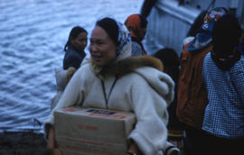 Photograph of an unidentified woman carrying a box