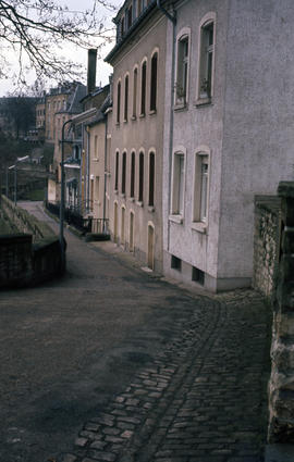 Photograph of a narrow, downhill street and buildings