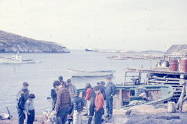 Photograph of several people standing on the shore of Battle Harbour, Newfoundland and Labrador
