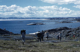 Photograph of a group of people walking towards the water in Frobisher Bay, Northwest Territories