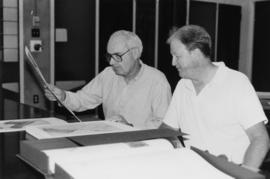 Photograph of Bill Birdsall, University Librarian, and an unidentified man looking at prints in t...