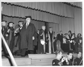 Photograph of a crowd of unidentified people in robes on stage