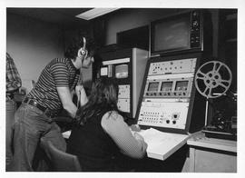 Photograph of two unidentified people operating television equipment