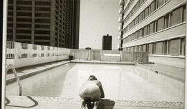 Photograph of a woman sitting next to a pool