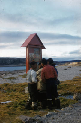 Photograph of children looking at a sign in Cape Dorset, Northwest Territories