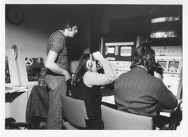 Photograph of three unidentified people at a switchboard