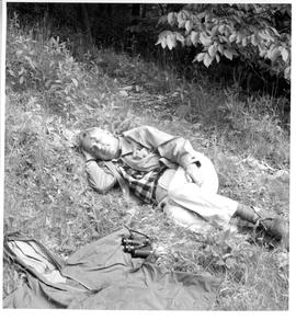 Photograph of an unidentified man resting on the ground