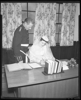 Photograph of Mr. & Mrs. Leil signing wedding documents