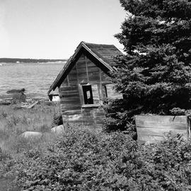 Photograph of an old shed on a shore