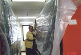 Photograph of Betty Sutherland holding tarps after the Kellogg Library flood 2004