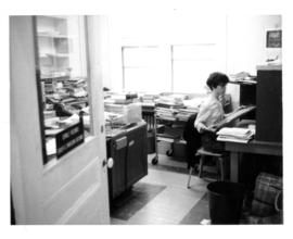 Photograph of Gloria Hardy working in the Serials Department of the 5963 College Street building