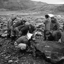 Photograph of a team of men removing a boulder from a path in Wakeham Bay, Quebec