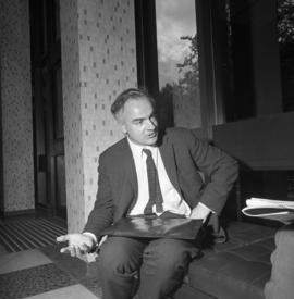 Photograph of an unidentified man sitting on a bench