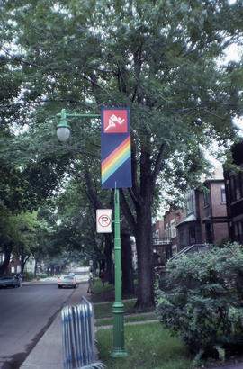 Photograph of a street sign featuring a rainbow and an active person