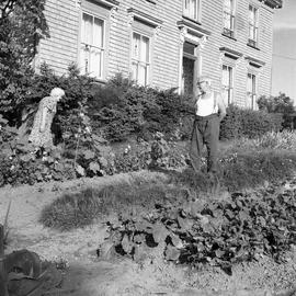Photograph of Mr. and Mrs. Ernest Arthur Farrant standing in a garden in front of a house