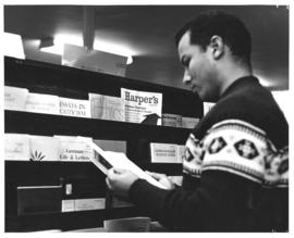 Photograph of a student reading a periodical in the Macdonald library