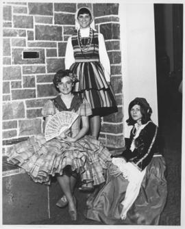 Photograph of three women in different international dress