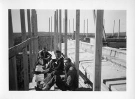 Photograph of men sitting on the Arts & Administration Building construction site