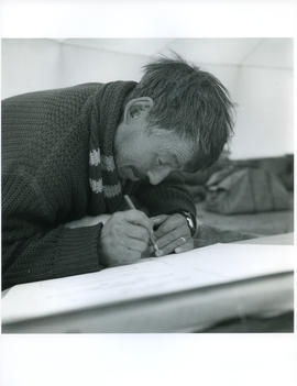 Photograph of an unidentified man drawing with a pencil