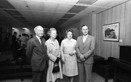 Photograph of four unidentified people at the presentation of a painting of Chester Stewart
