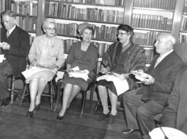Photograph of unidentified people eating in a library