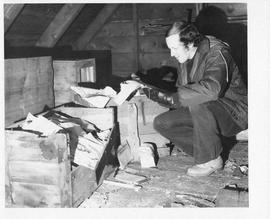 Photograph of Charles Armour looking at crates of documents