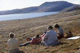 Photograph of a group of people reclining outdoors at Tellik Inlet, Northwest Territories