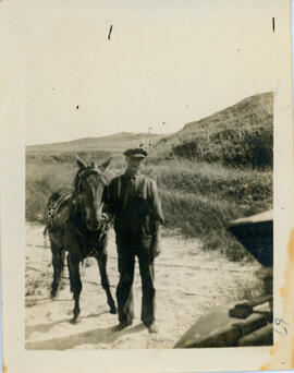 Photograph of Sydney Osborne standing next to a horse on Sable Island