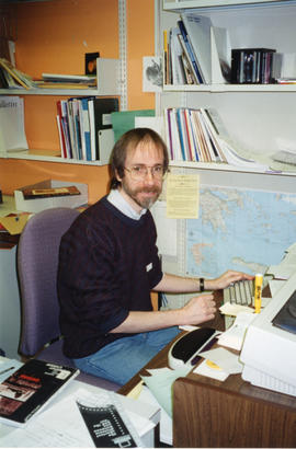 Photograph of librarian Ian Colford working at his desk in the Killam Memorial Library