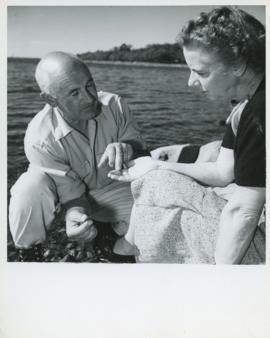 Photograph of Edith and Thomas Head Raddall discussing ancient arrowheads found at the Indian Gar...