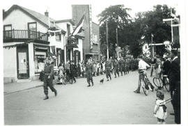 Photograph of a parade of Canadian Armed Forces marching down a street in Holland