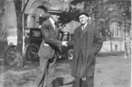 Photograph of A. S. MacKenzie shaking hands with an unidentified man