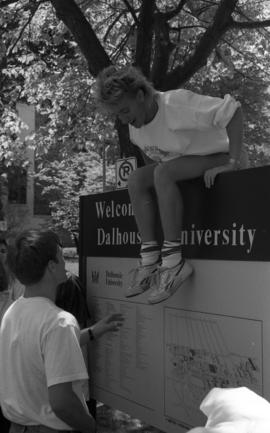 Photograph of a student on the Dalhousie welcome sign