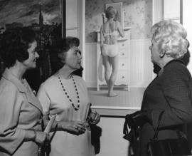 Photograph of three unidentified women looking at a painting